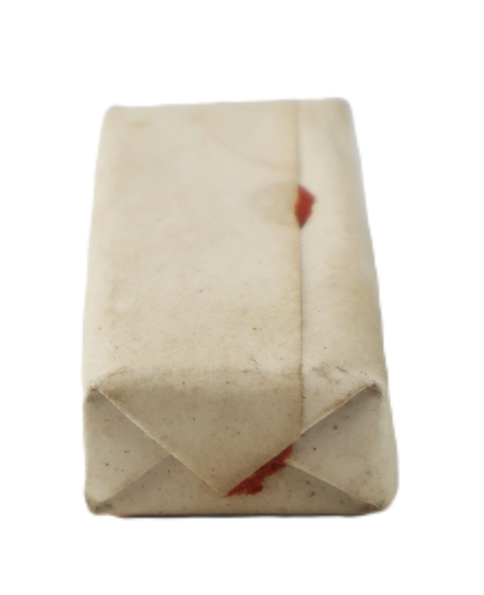 A small rectangular package of Dr. Strong’s Vegetable Stomach Pills, wrapped in plain, slightly worn paper with visible fold lines and a faint red seal mark, is photographed on a white background.