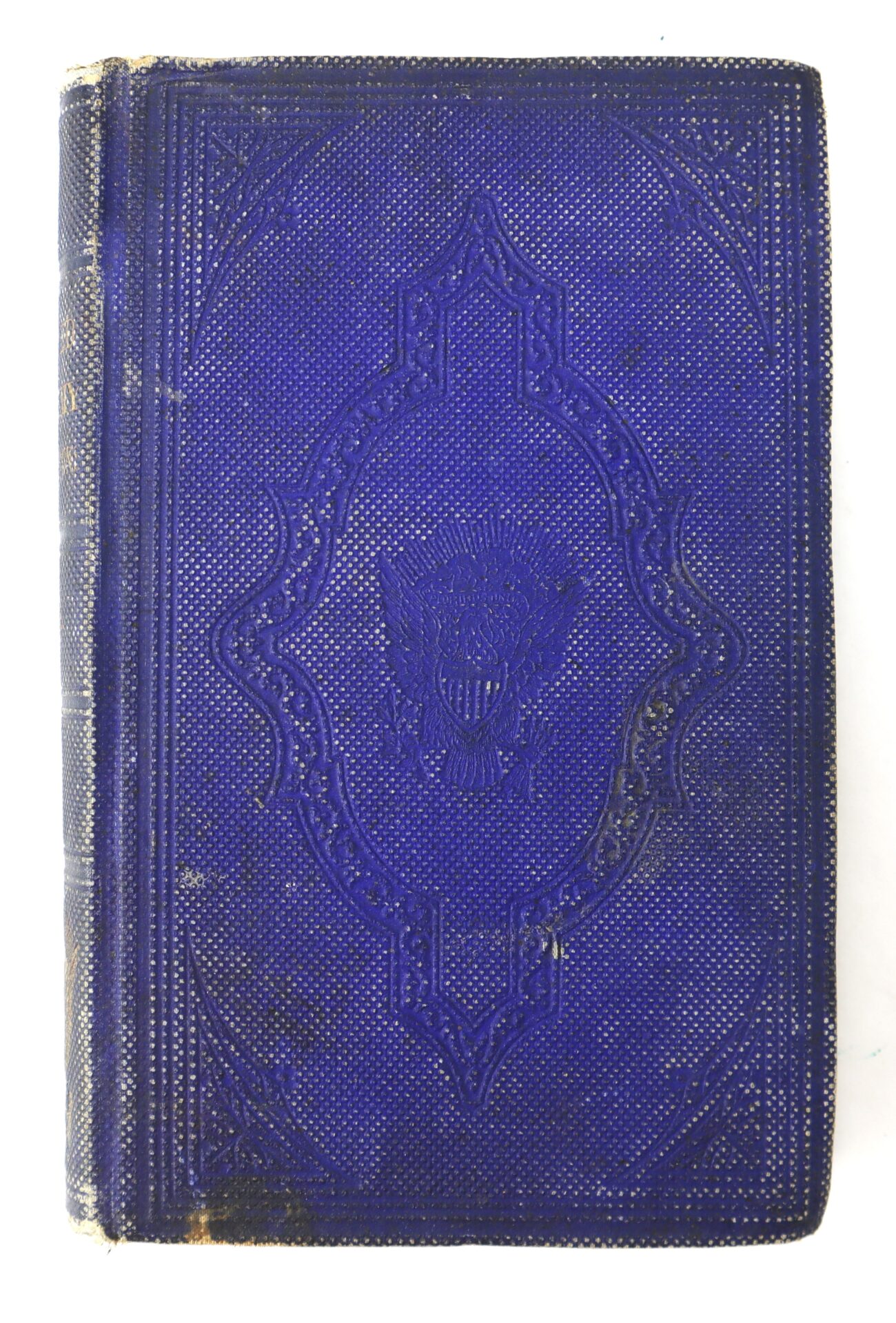 A worn blue hardcover book with an embossed ornate border and a central shield design on the front cover, showing some signs of age.