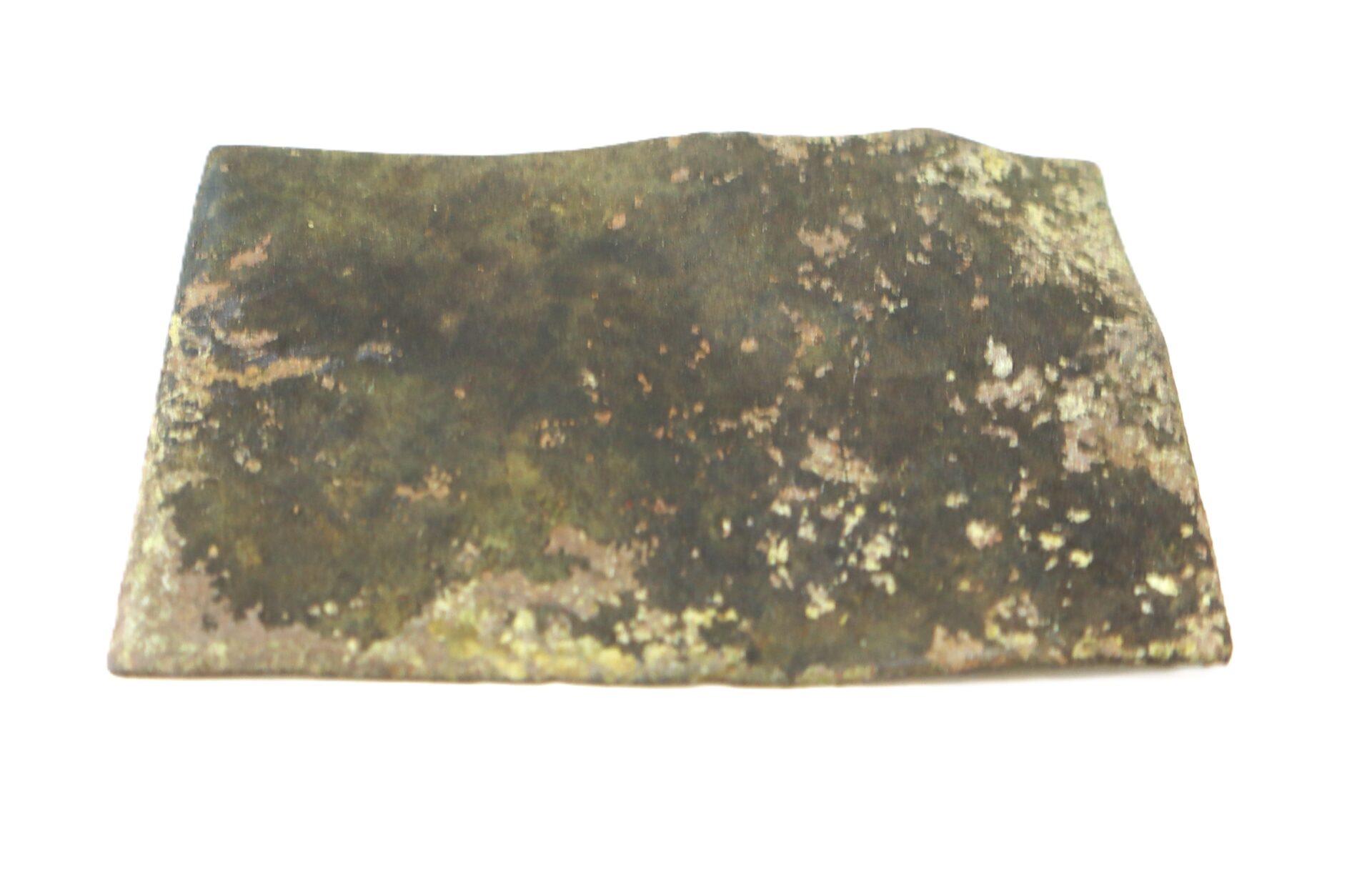 A rectangular, flat, corroded metal plate with a mottled surface, showing patches of rust and discoloration, on a white background.