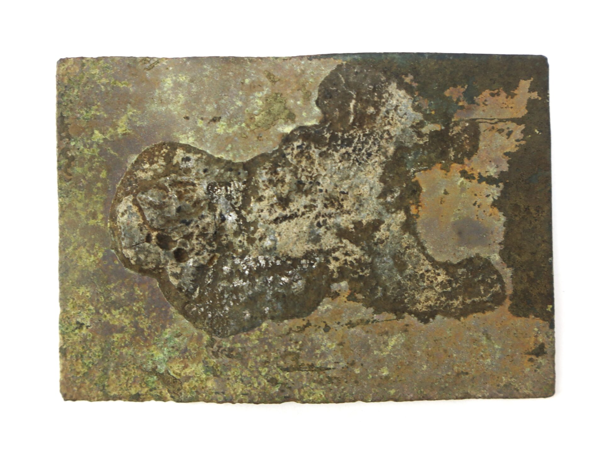 A rectangular, corroded metal plate with patches of rust, discoloration, and uneven surface texture, placed on a white background.