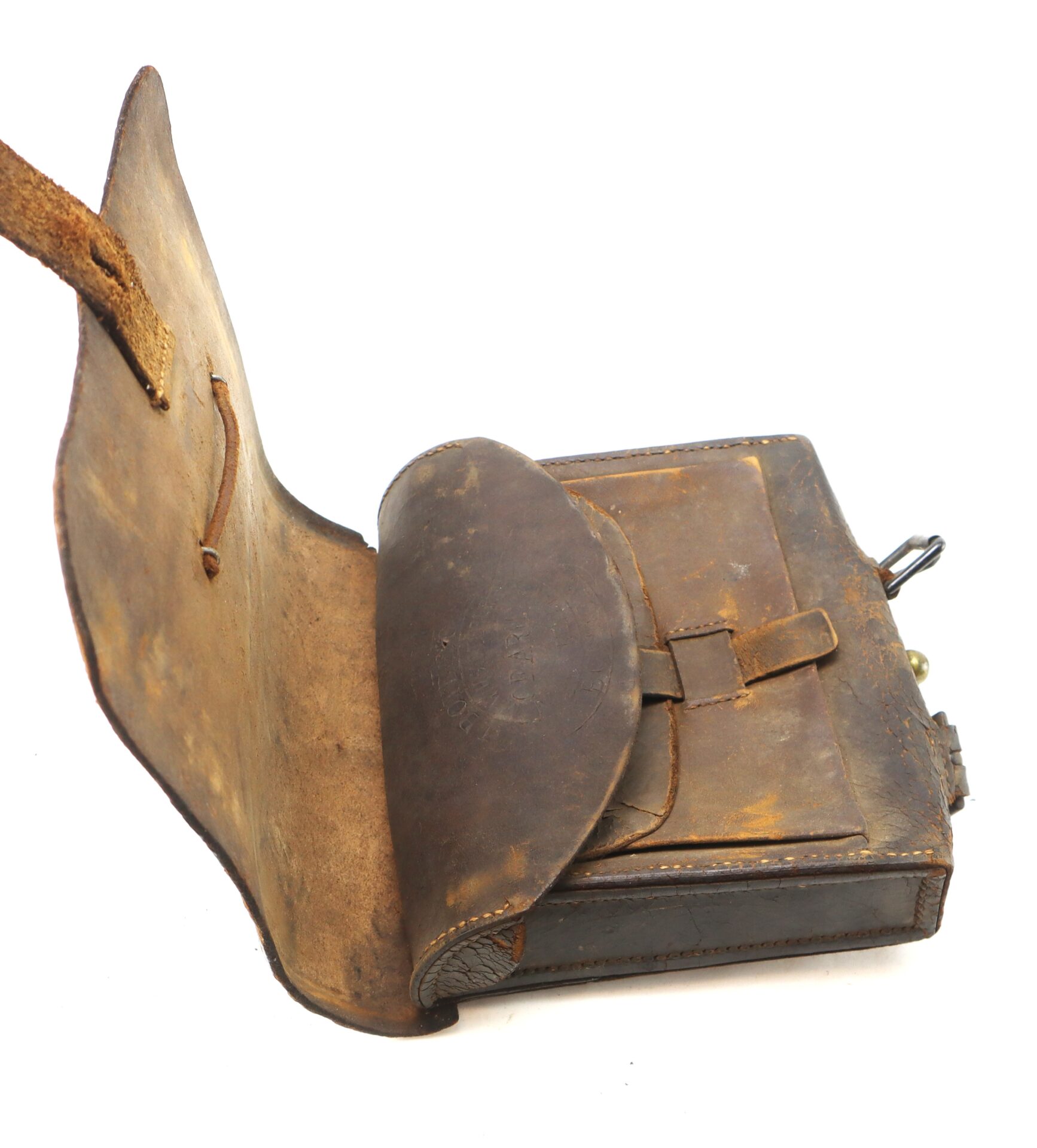 A worn, vintage leather satchel with the flap open, revealing an inner compartment and strap.