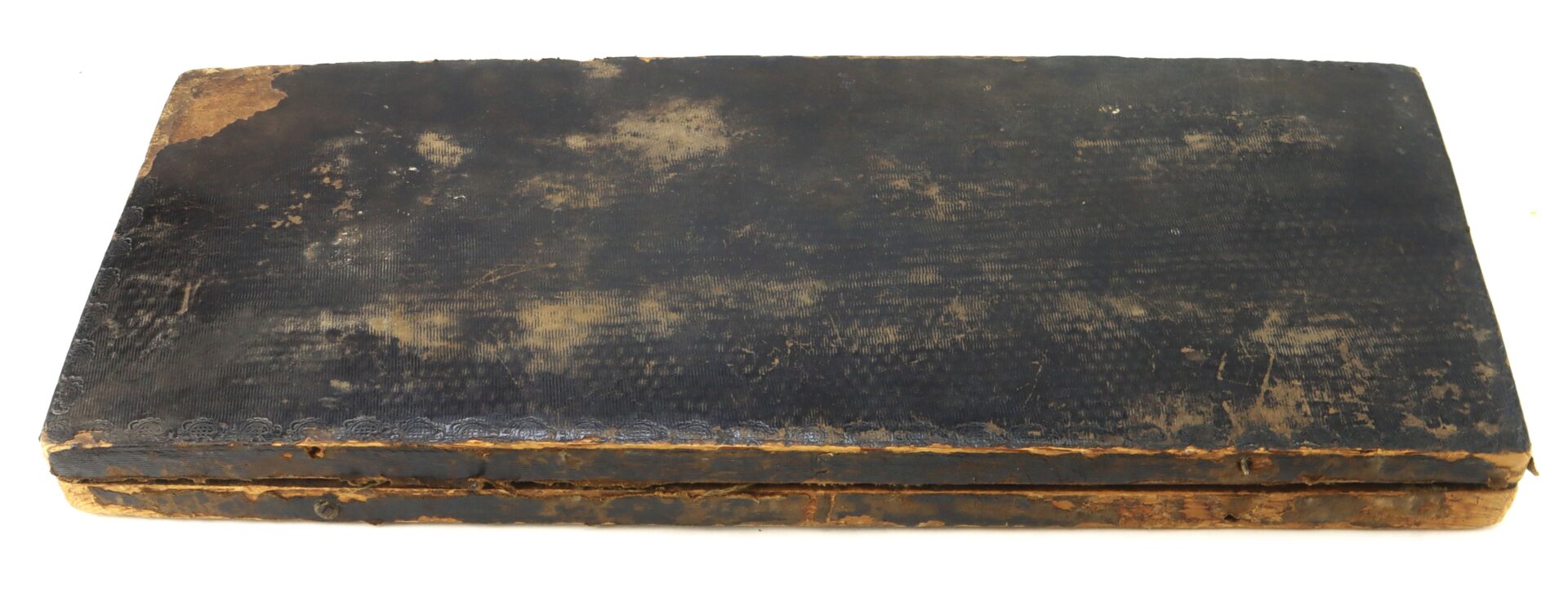 A worn, rectangular, black leather case with visible scuffs and faded spots, lying closed on a white background.
