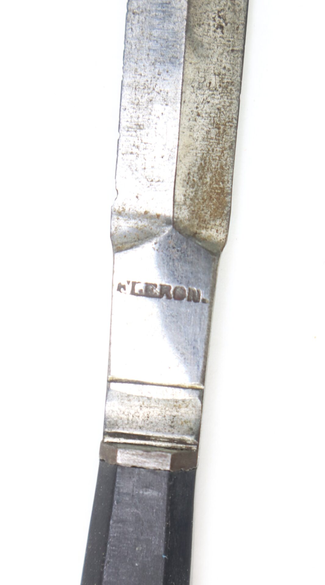 Close-up of a metal tool or utensil with the word "VERON" engraved on the handle, showing signs of wear and tarnish.