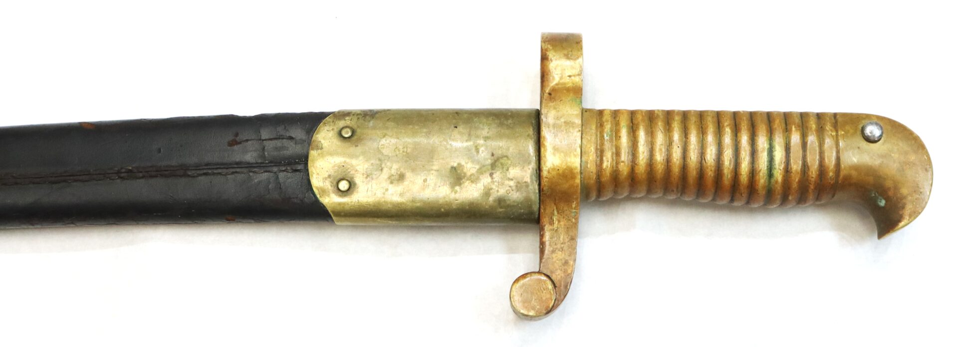 A close-up of a brass-handled sword or bayonet with a ribbed grip and a black sheath against a white background.