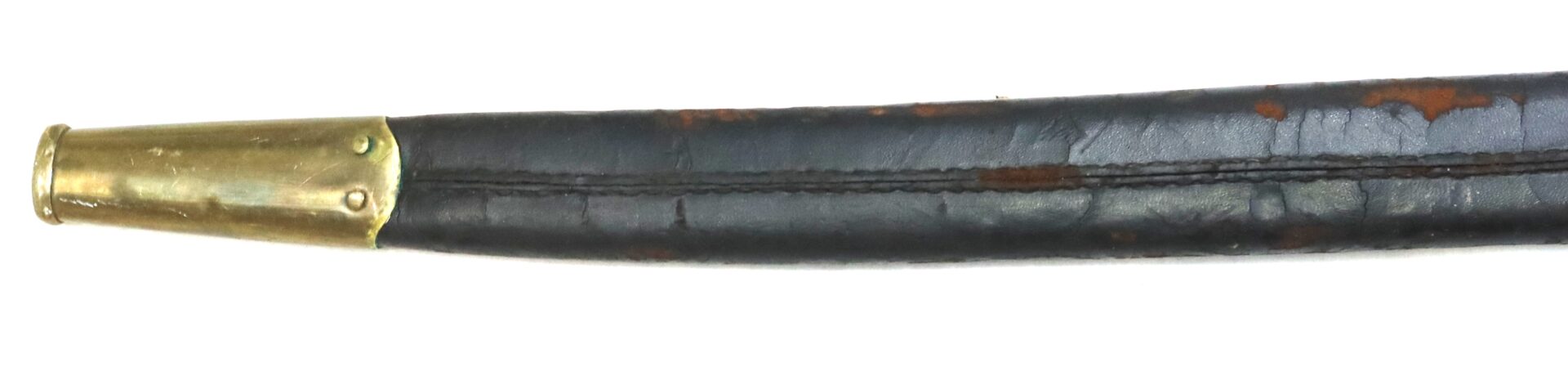 Close-up of a weathered leather scabbard with a brass tip, showing visible stitching and areas of rust and wear.