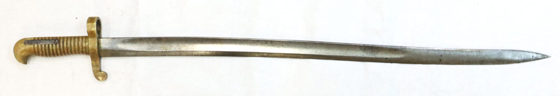 A vintage metal bayonet with a ribbed handle, guard, and slightly curved single-edged blade, photographed on a white background.