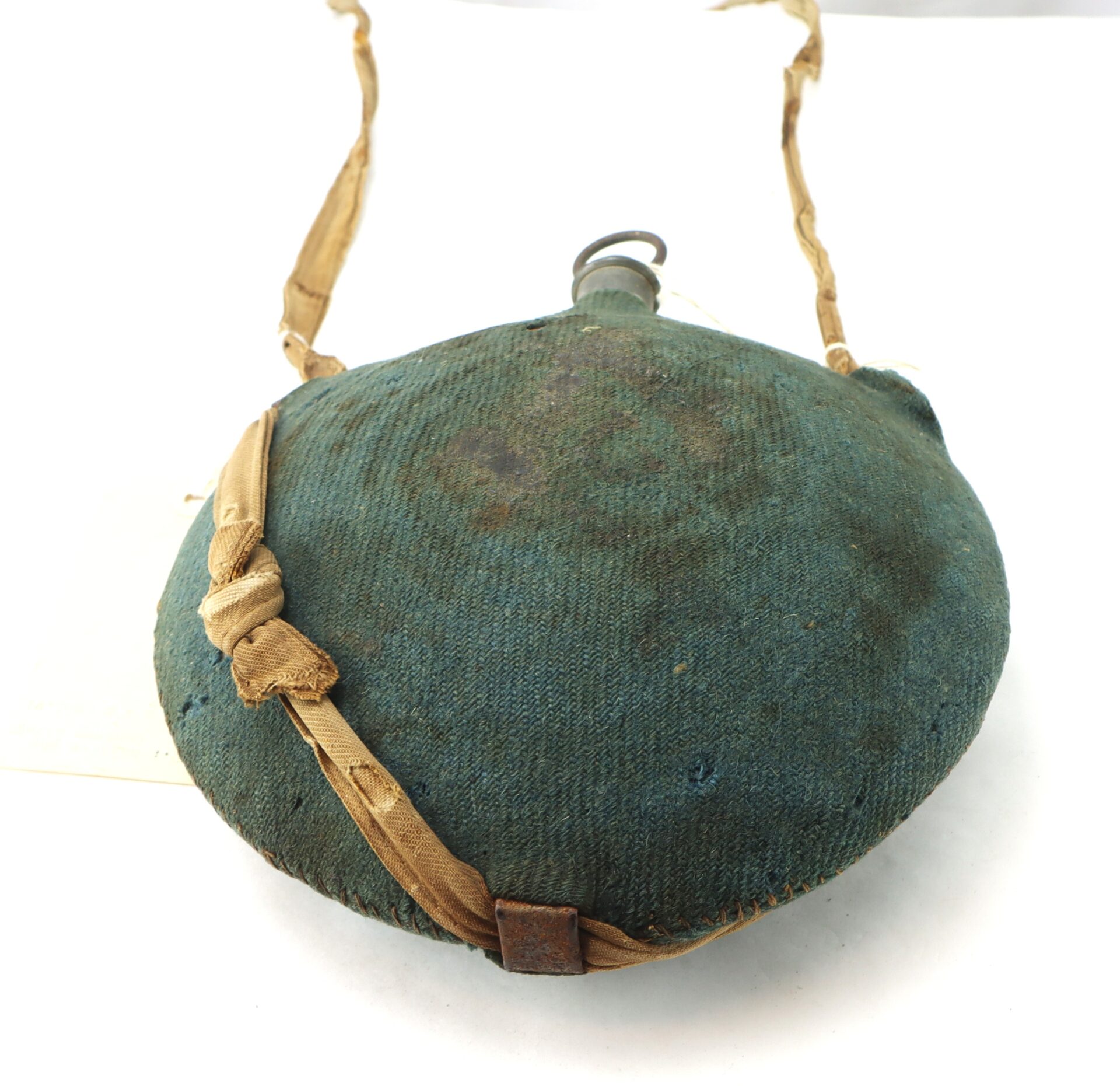 The Outstanding Identified Massachusetts Heavy Artillery Canteen of Benjamin D. Reed, 30th Unattached Co., features a vintage round canteen with a worn blue fabric cover and tan strap, shown front-facing against a white background.
