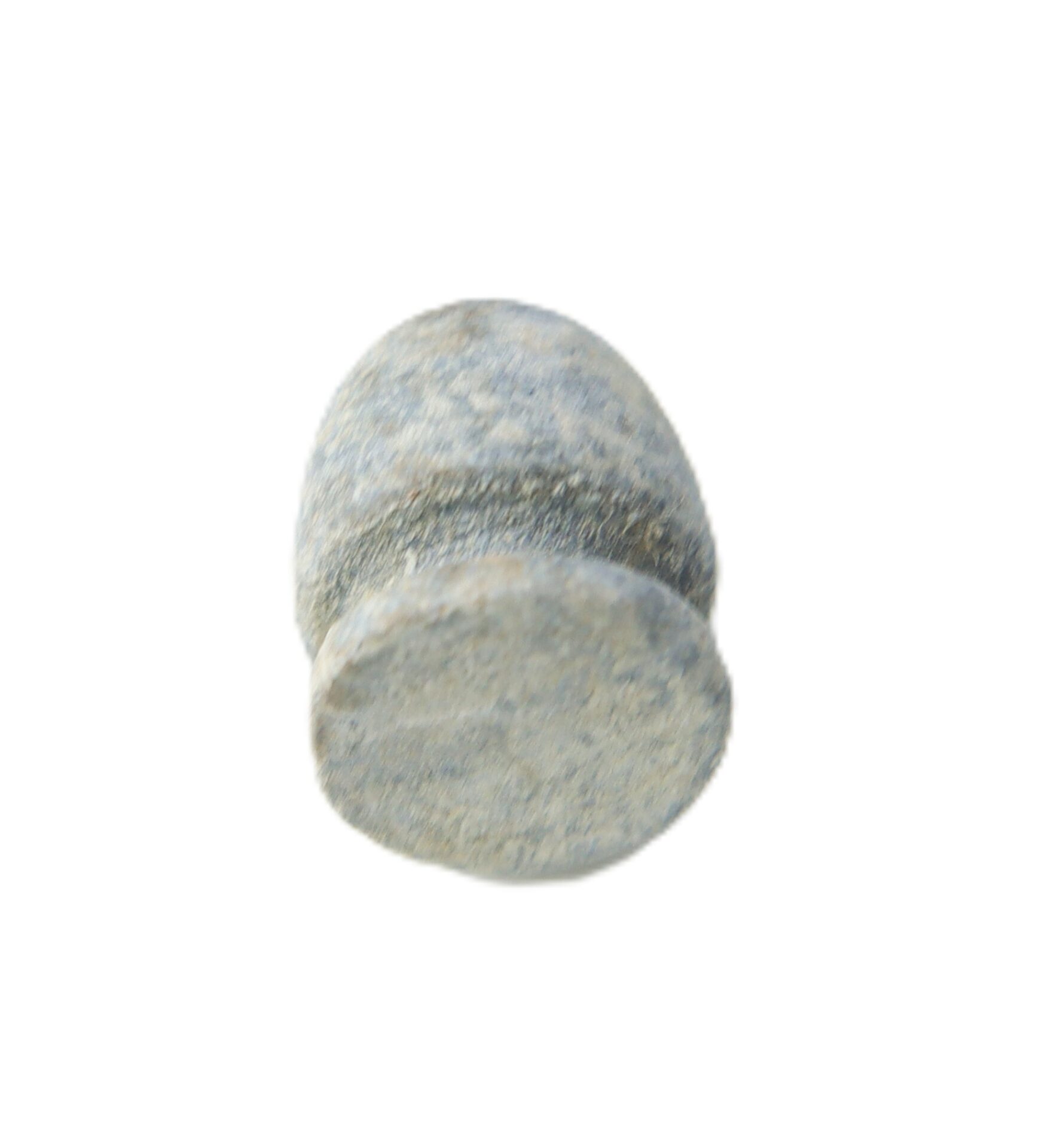 A close-up of a small, cylindrical, gray stone object with rounded ends, isolated on a white background.