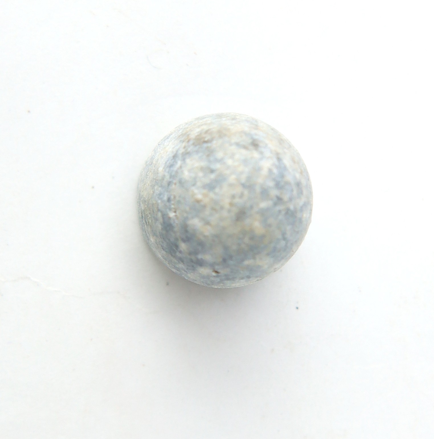 A single round, grayish-blue sphere with a textured surface is positioned against a plain white background.