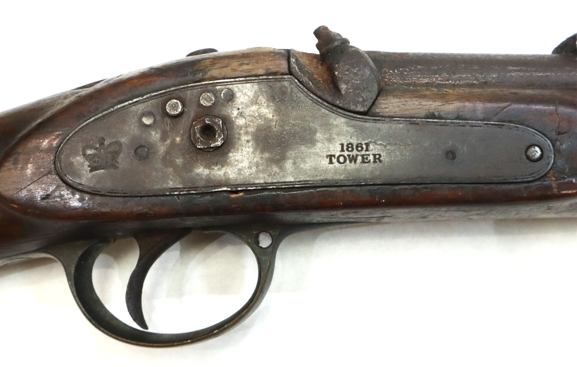 Close-up of the lockplate and trigger of an antique rifle marked "1861 Tower," showing signs of wear and age.