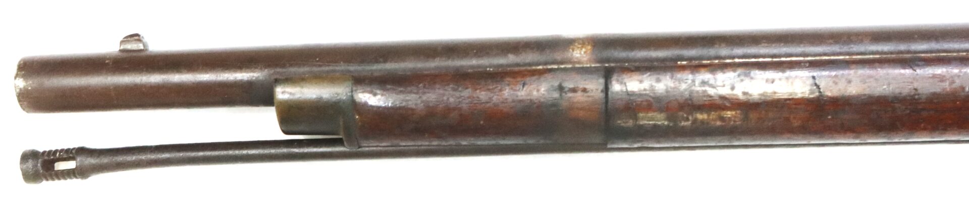 Close-up view of the barrel and underbarrel cleaning rod of an old, worn rifle, showing metal and wood components against a white background.