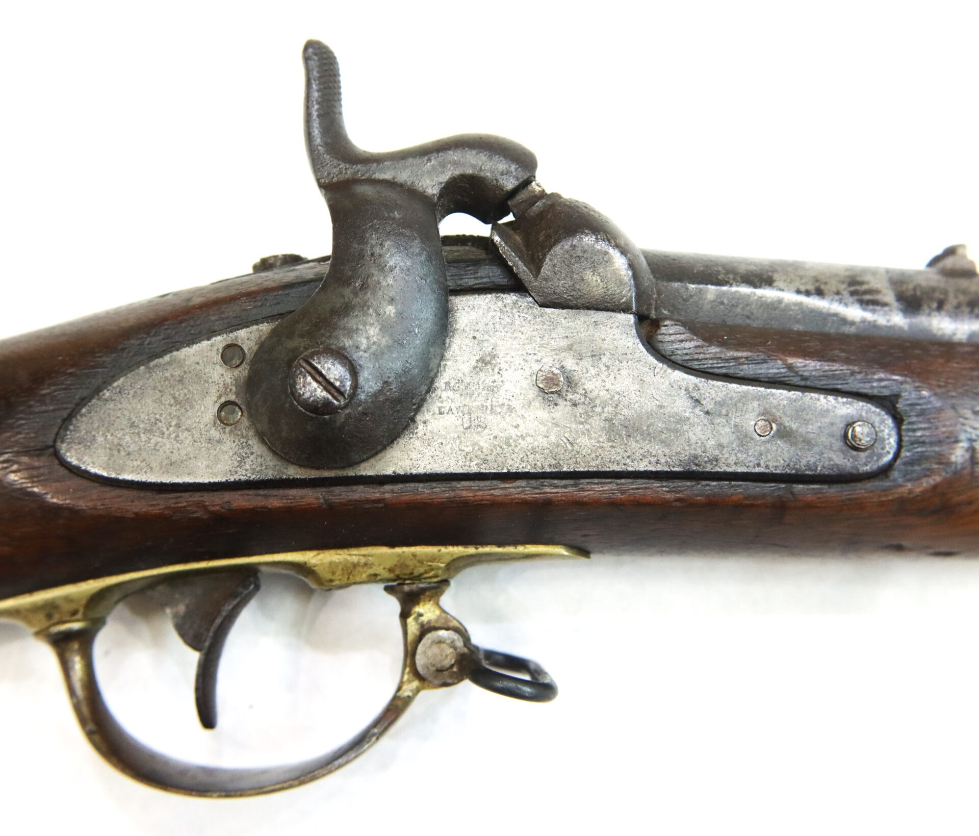 Close-up of an antique flintlock rifle mechanism, showing the hammer, trigger, and part of the wooden stock against a white background.
