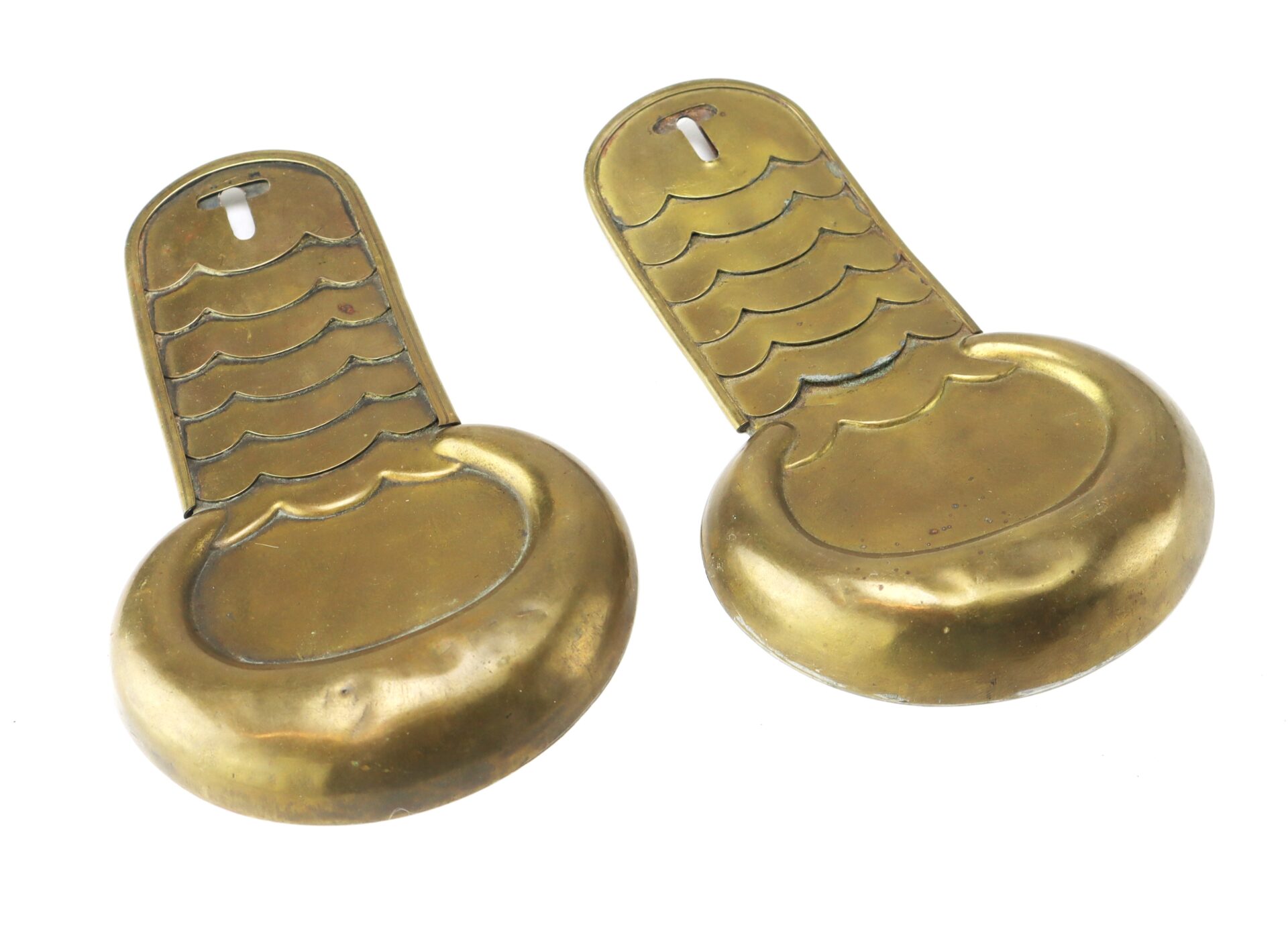 A pair of brass stirrup-shaped objects resembling Civil War Shoulder Scales, featuring engraved details and a slot at the top of each handle.