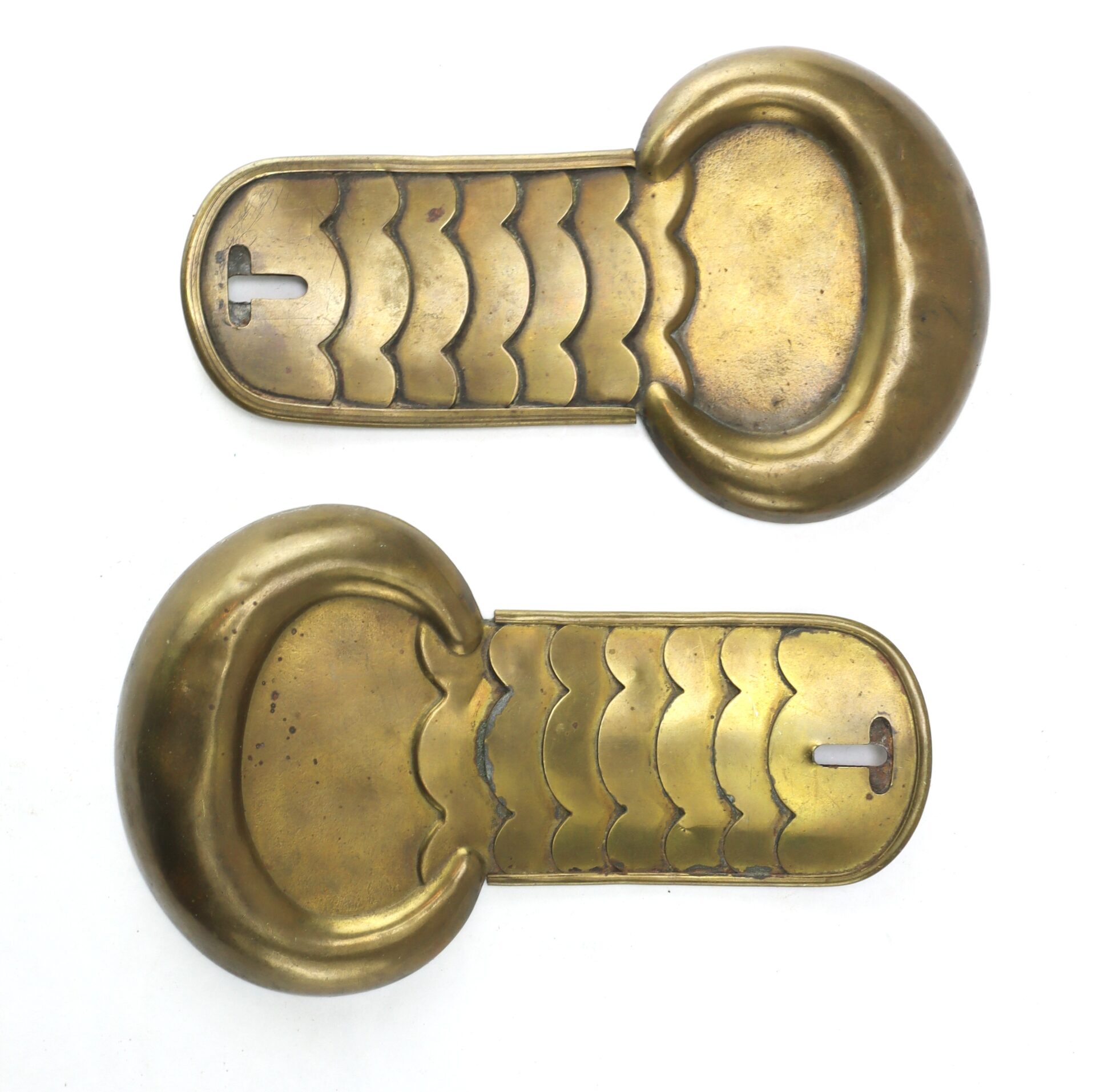 Two brass shoulder epaulettes with scalloped designs and keyhole-shaped openings on one end, displayed on a white background.