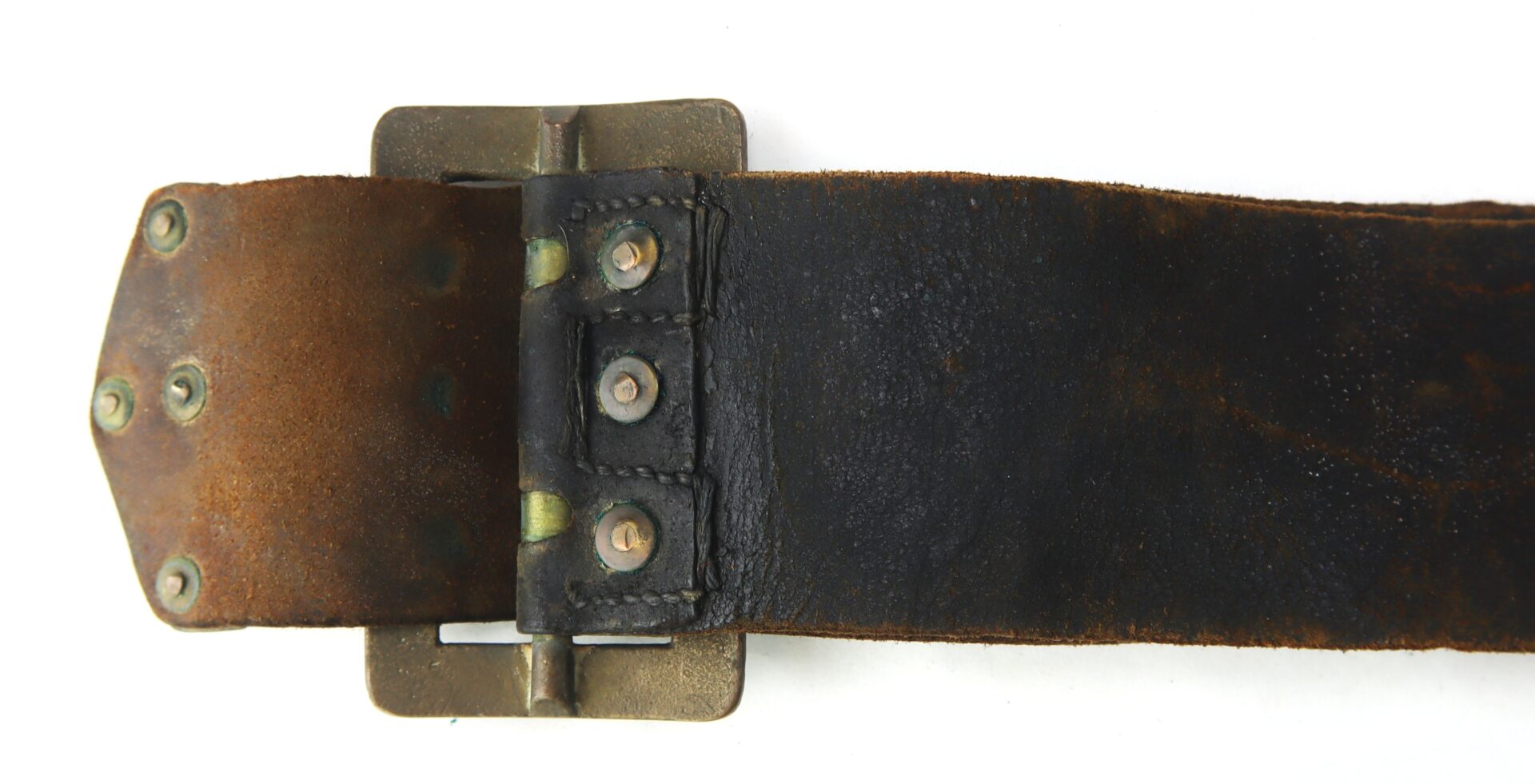 Close-up of a worn, black and brown leather belt with a metal buckle and visible rivets against a white background.