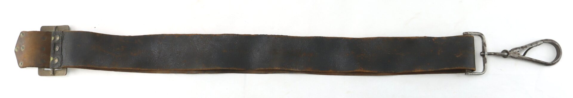 A worn, dark leather strap with a metal buckle on one end and a metal clasp hook on the other, laid flat on a white background.