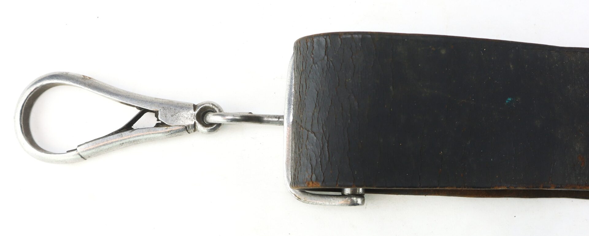 A close-up of the Cavalry Carbine Sling shows its metal clasp attached to a worn, dark leather strap against a white background.
