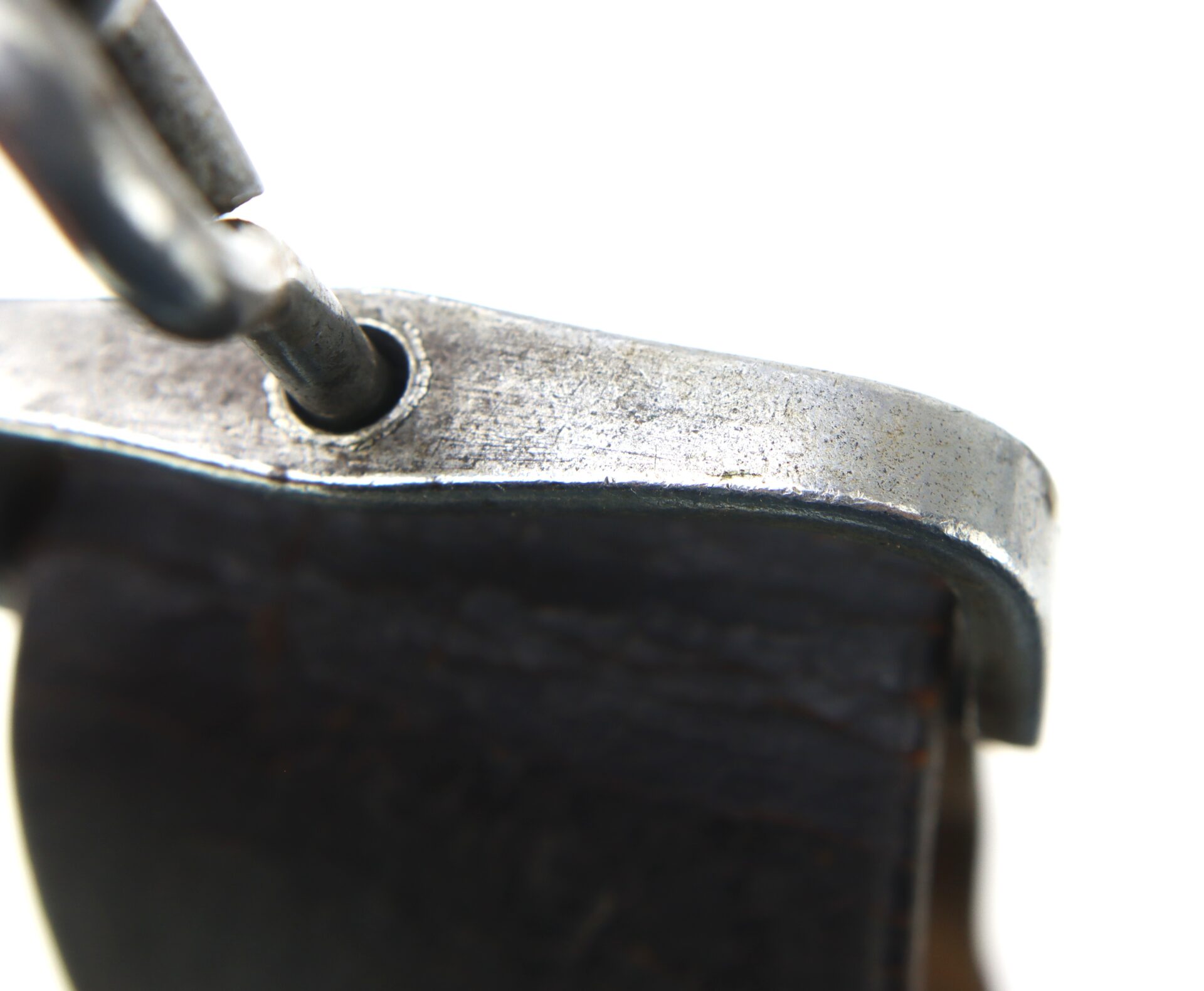 Close-up of the Cavalry Carbine Sling's metal clasp attached to a dark leather strap, set against a bright white background.