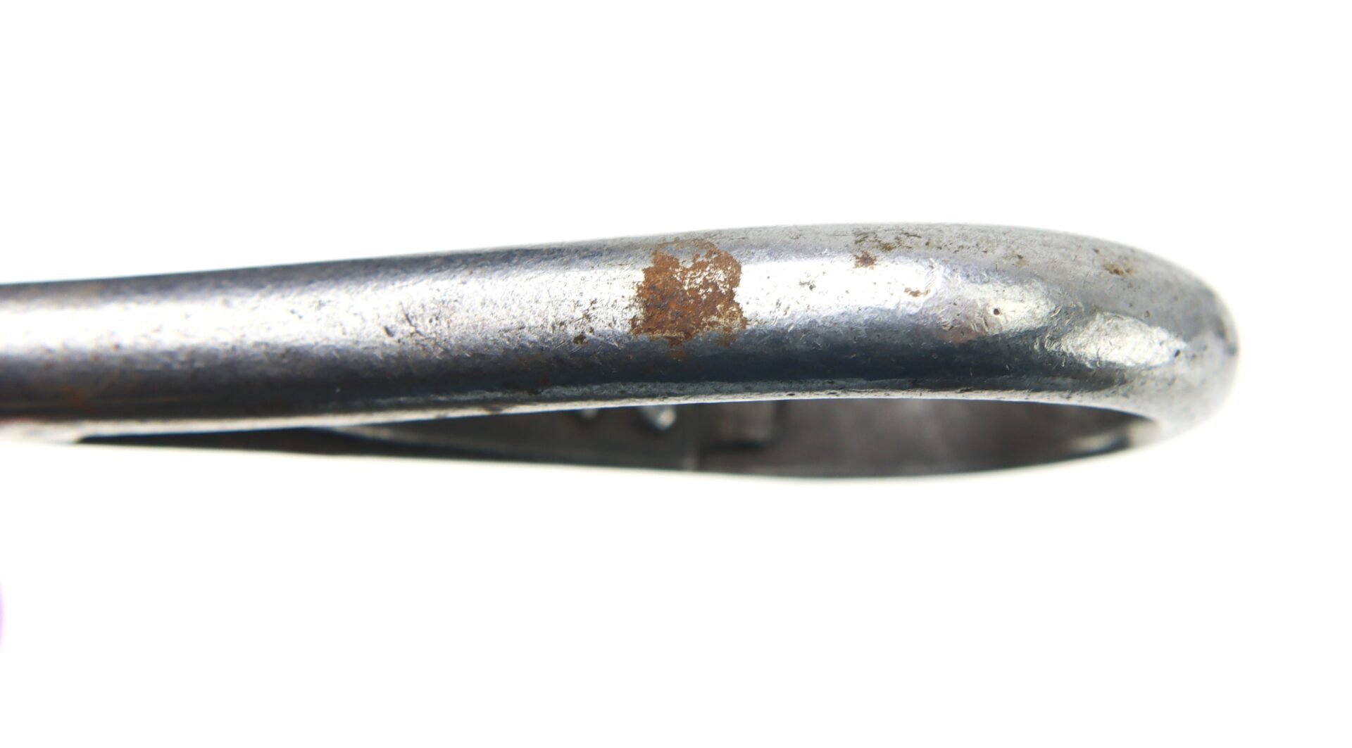 Close-up of a Cavalry Carbine Sling with a curved metal edge and a patch of rust on its surface, set against a white background.