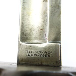 Close-up of a metal blade stamped with the engraving "TIFFANY & CO NEW-YORK" near the base.
