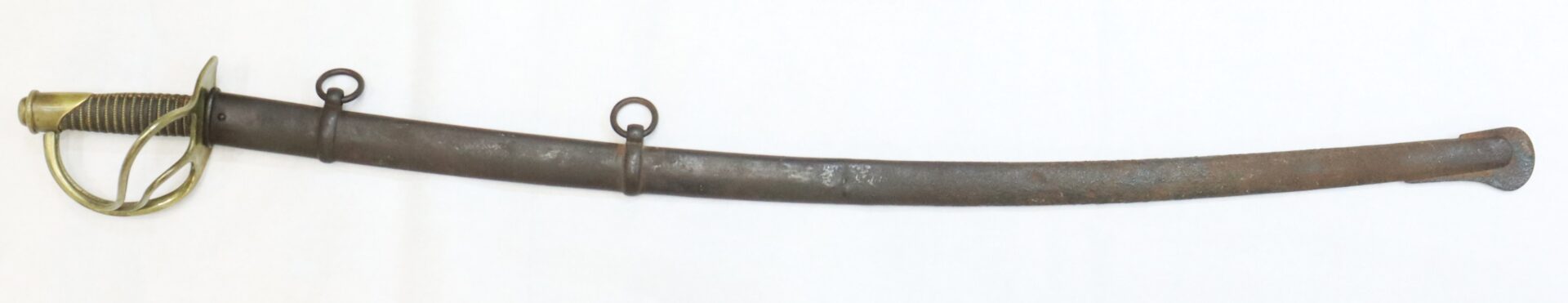 A curved metal sword with a brass handguard and grip, sheathed in a dark scabbard featuring two suspension rings, displayed on a white background.