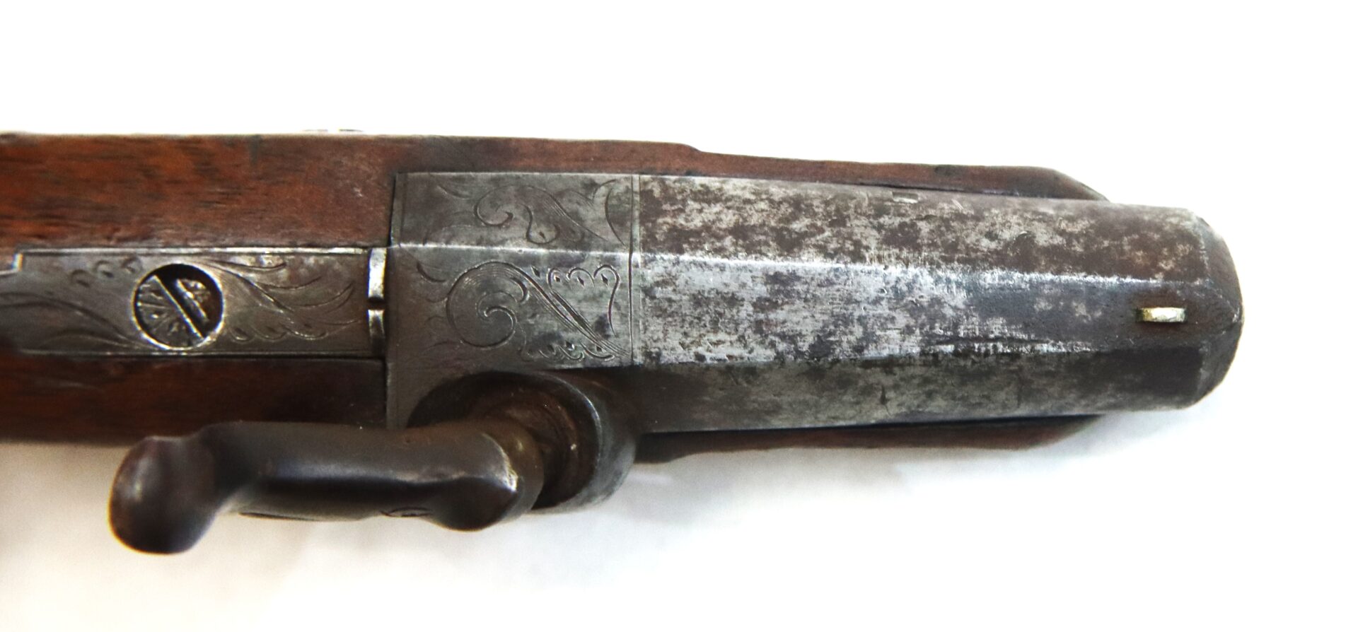 Close-up of an antique rifle bolt and receiver with visible engravings and signs of wear on the metal and wooden parts.