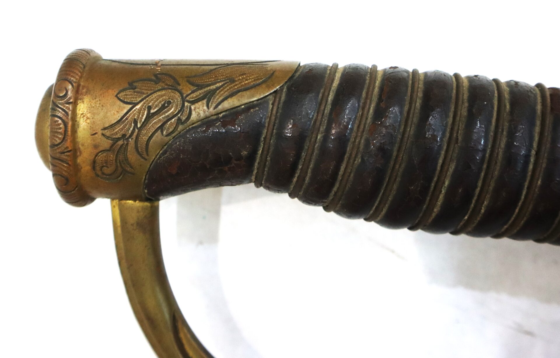 Close-up of the hilt of a sword with a brown leather-wrapped grip and ornate brass detailing.
