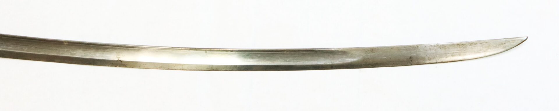 A close-up of the curved, sharpened blade of a sword against a plain white background.