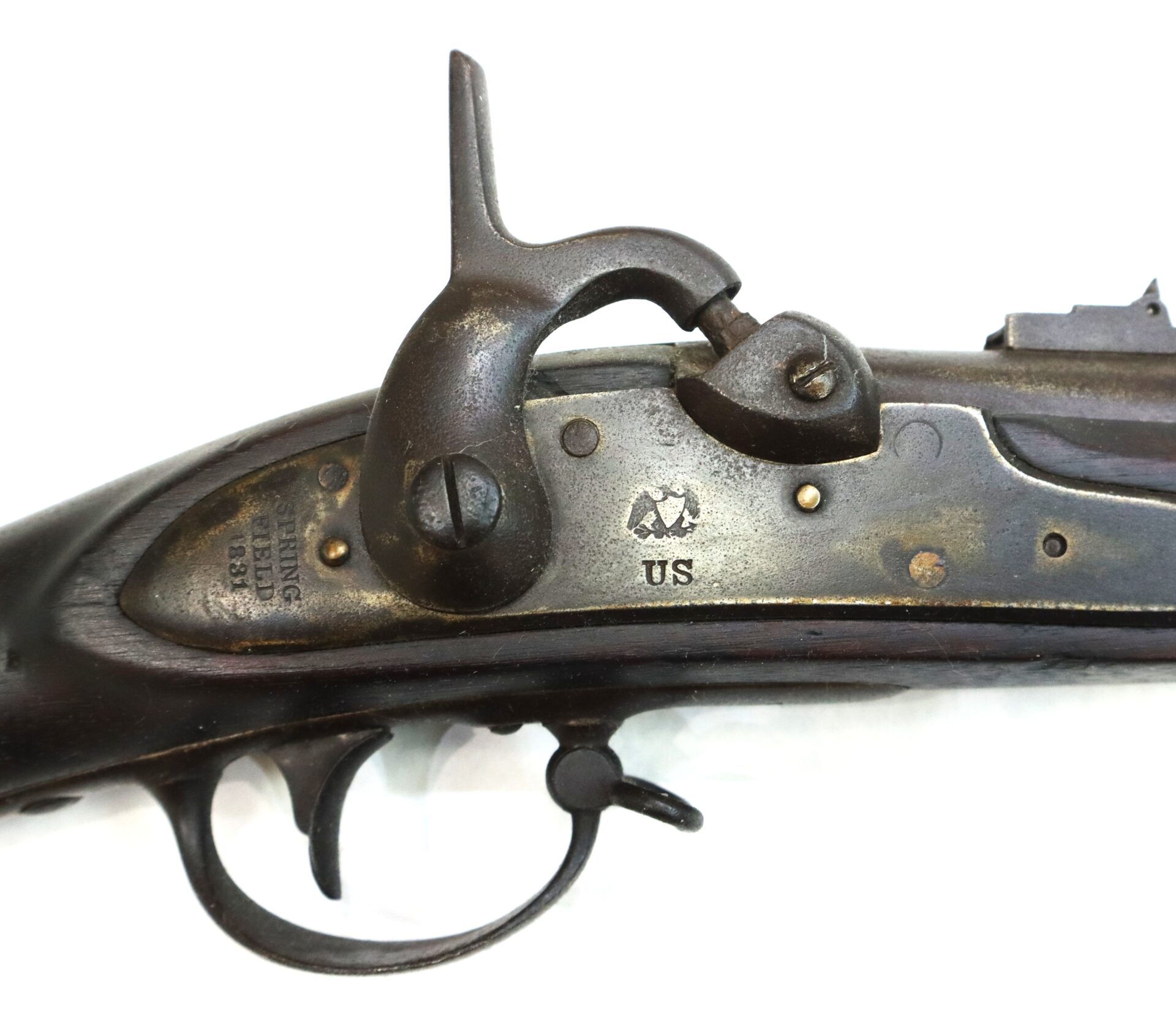 Close-up of the lock mechanism of an antique US-marked musket, showing the hammer, trigger, and stamped markings on the metal plate.