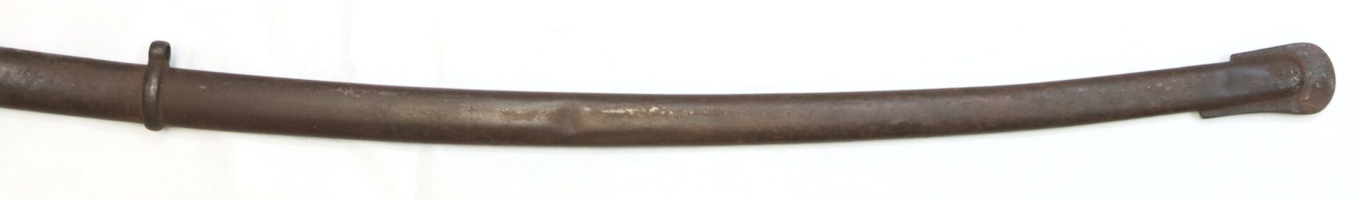 A curved, rusted metal scabbard with a ring near one end and a flattened tip, placed on a white background.