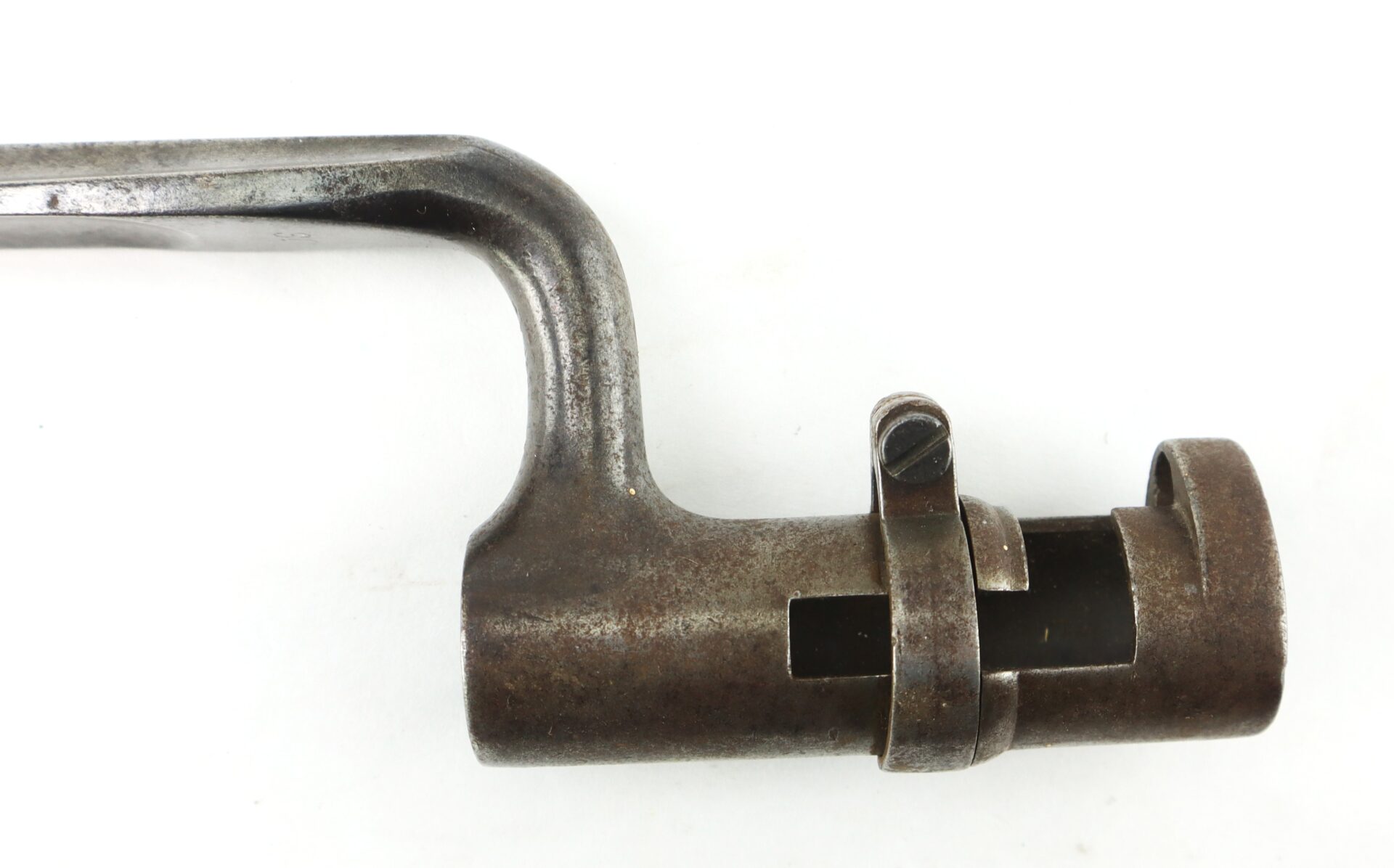 A close-up of a Model 1855 .58 Caliber Triangular Socket Bayonet featuring its locking mechanism and aged, rusted metal against a white background.