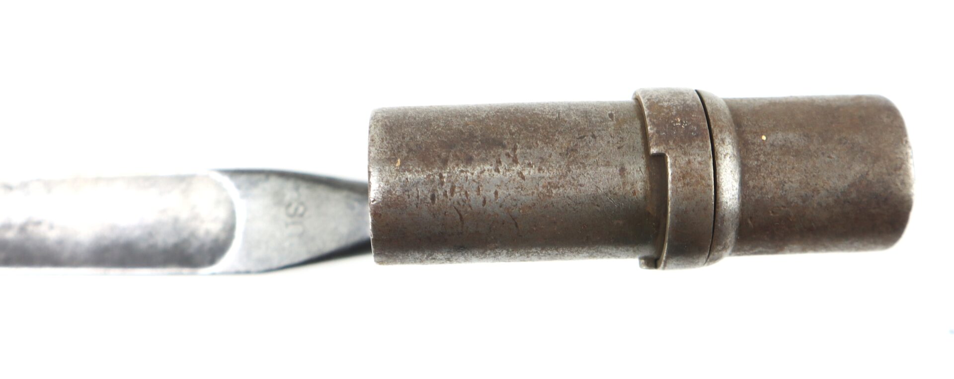 Close-up of a Model 1855 .58 Caliber Triangular Socket Bayonet, featuring a cylindrical, slightly rusted body and flat, chisel-like blade on one end, set against a white background.