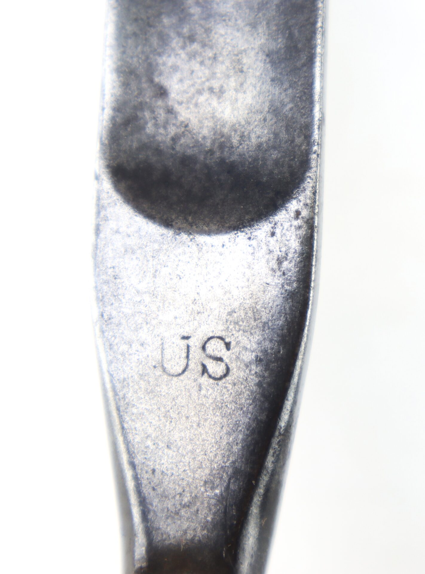 Close-up of a Model 1855 .58 Caliber Triangular Socket Bayonet with the letters "US" engraved on its metallic surface.