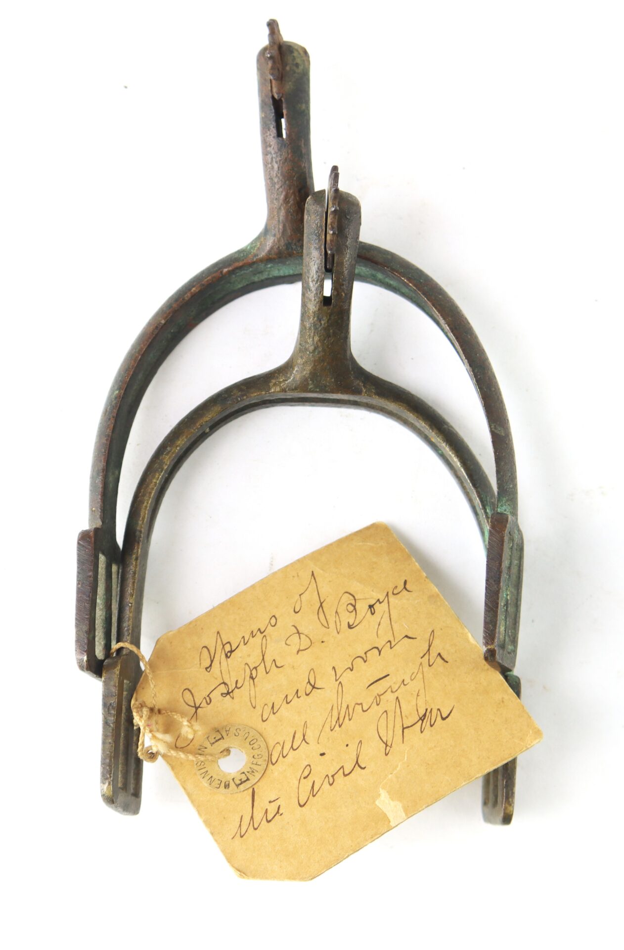 A pair of worn metal spurs with a handwritten tag attached, stating they were used by Joseph S. Boyce during the Civil War.