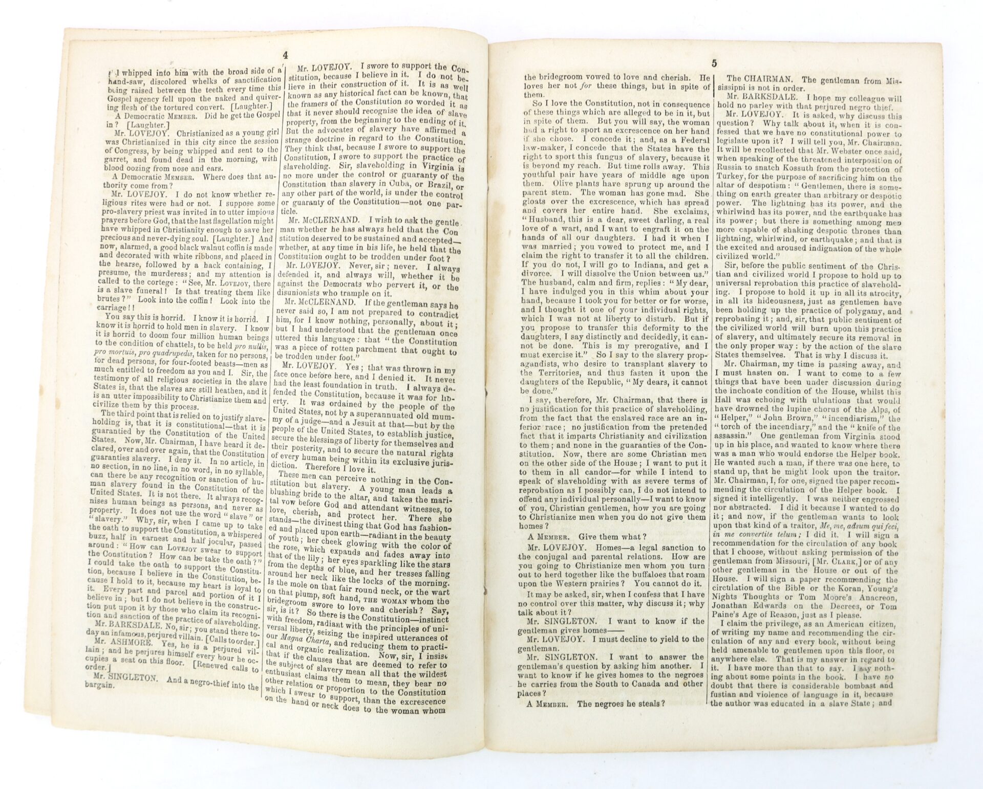 An open book displaying two pages of dense, black printed text arranged in three columns per page on off-white paper.