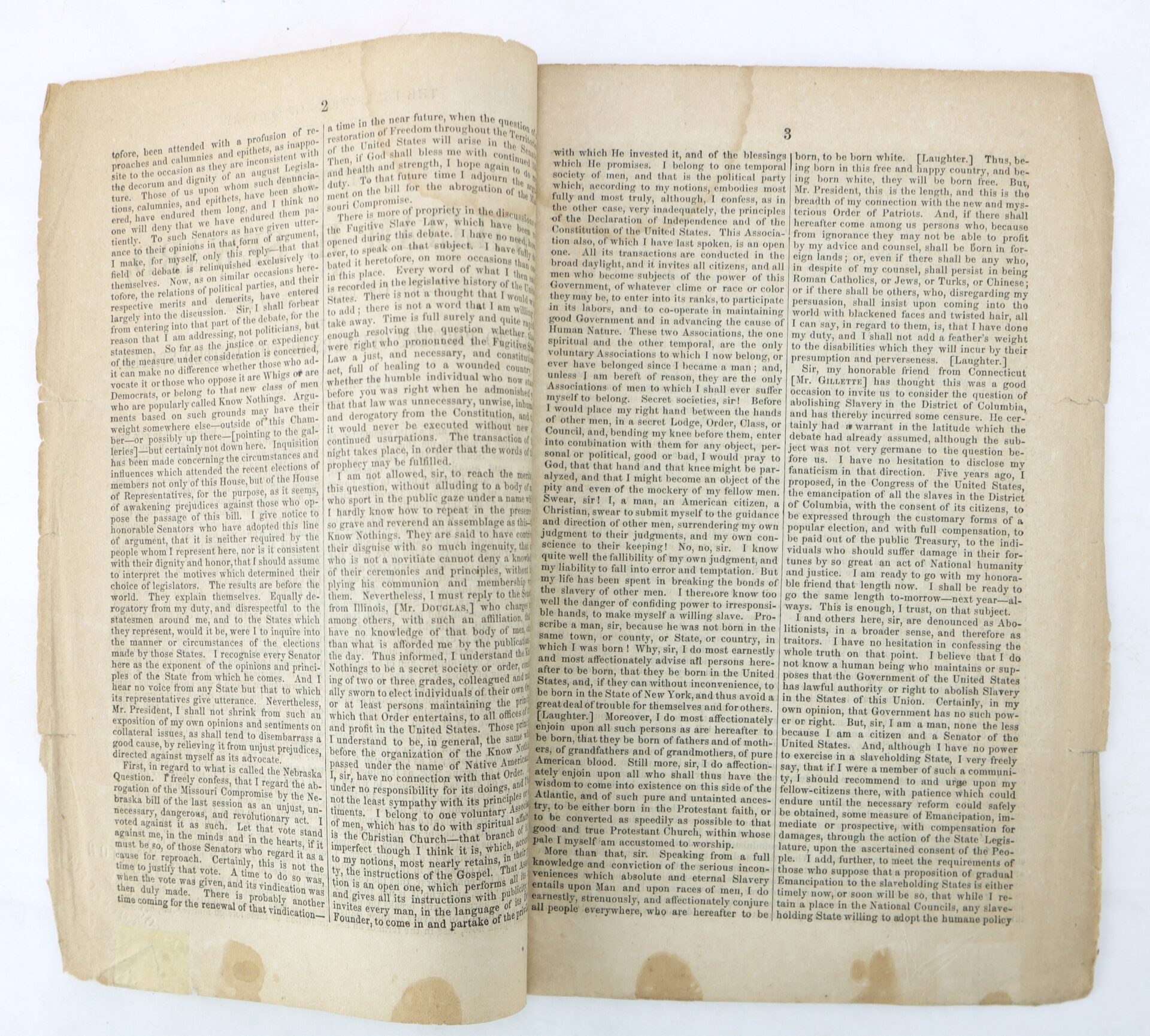 An open antique book showing two pages filled with dense, small black text in three columns on yellowed, worn paper.
