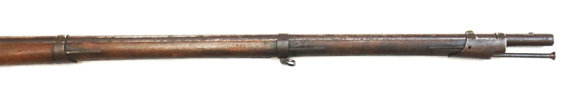 The image shows the front section of a vintage, brown wooden rifle barrel with metal fittings and a front sight.