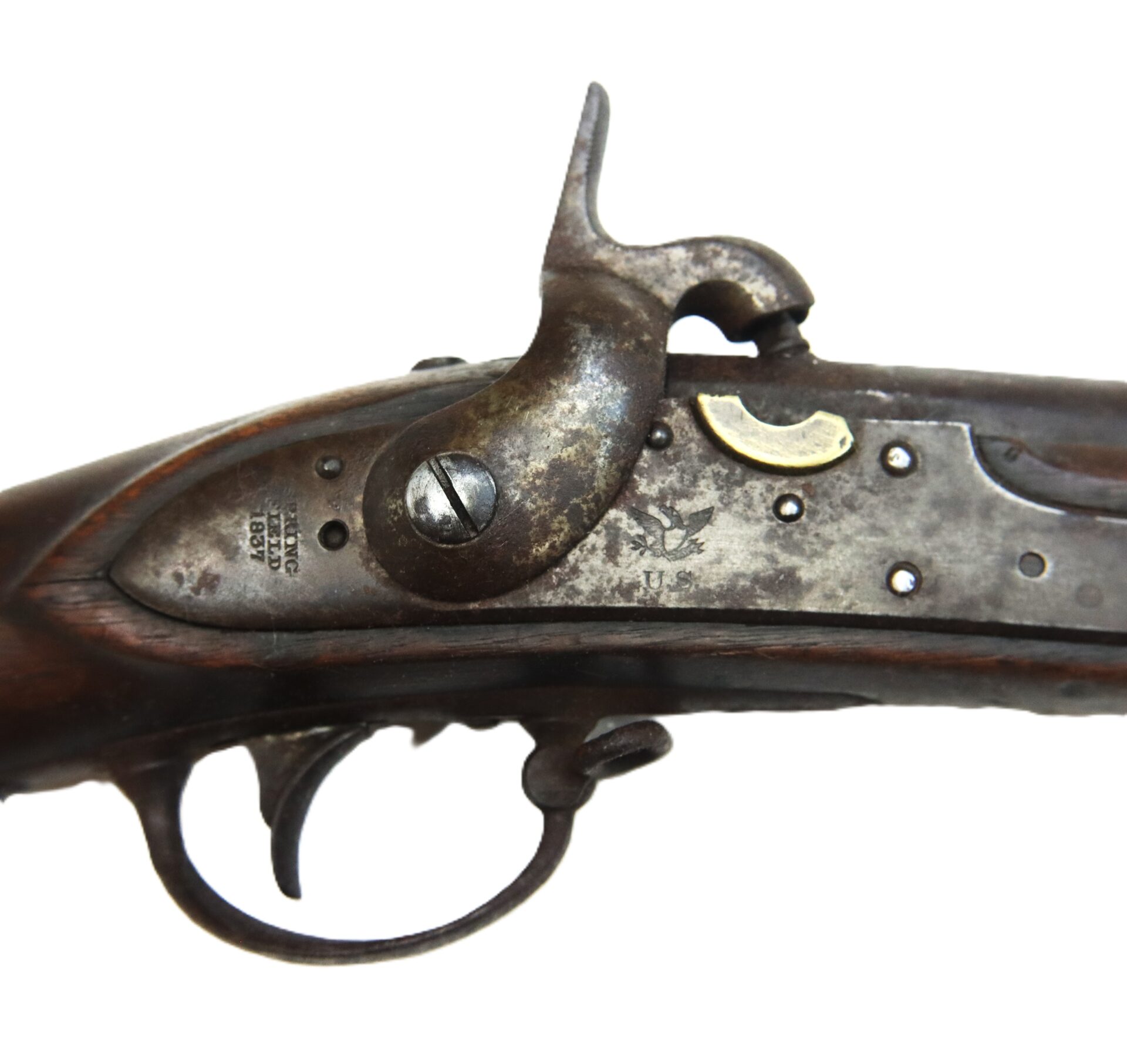 Close-up of an antique flintlock musket mechanism, showing the trigger, hammer, and engraved metal plate with visible wear and patina.