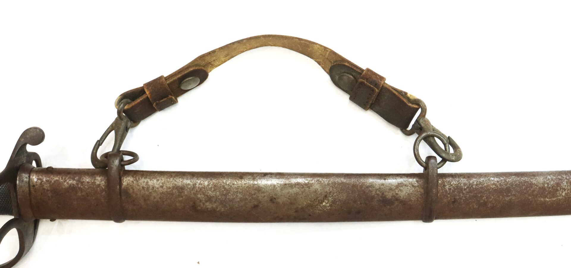 A close-up of a weathered metal sword scabbard with a worn leather strap and metal buckles attached.