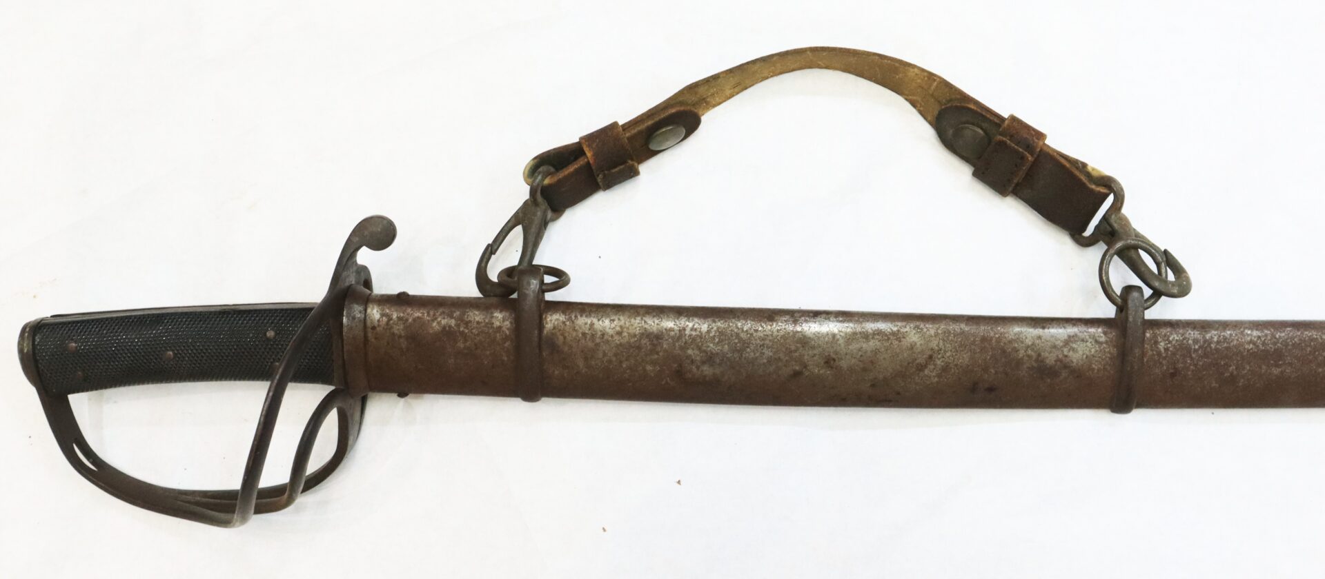 A vintage cavalry sword with a metal scabbard and a worn leather shoulder strap, displayed on a white background.