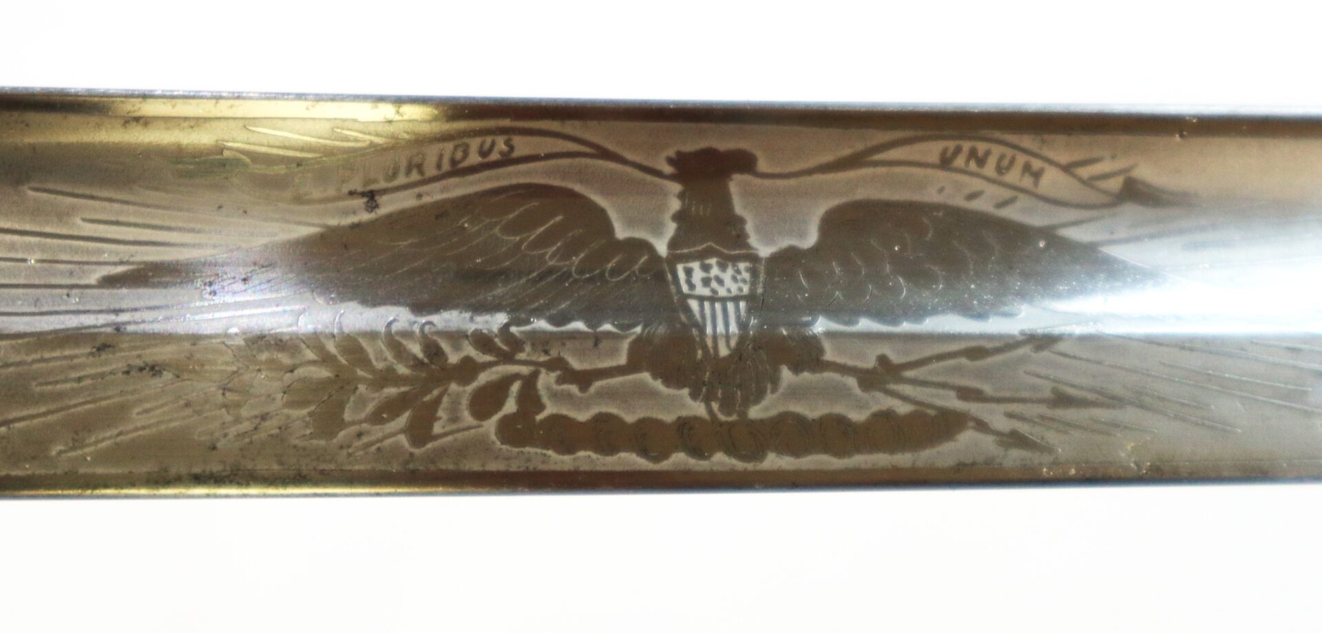 Close-up of an engraved eagle with spread wings, shield on its chest, and a banner reading "E Pluribus Unum" above its head.