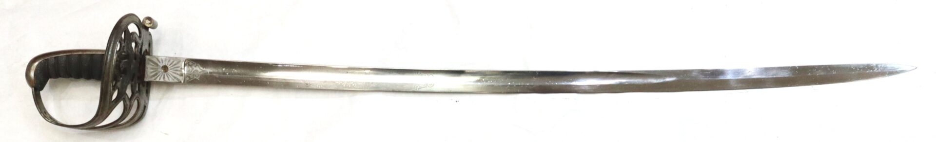A single-edged sword with a curved blade, ornate hand guard, and a black grip, displayed on a white background.