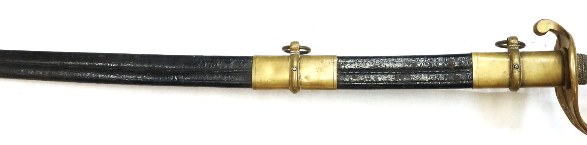 A close-up of a black scabbard with two brass fittings and part of a brass sword hilt on a white background.