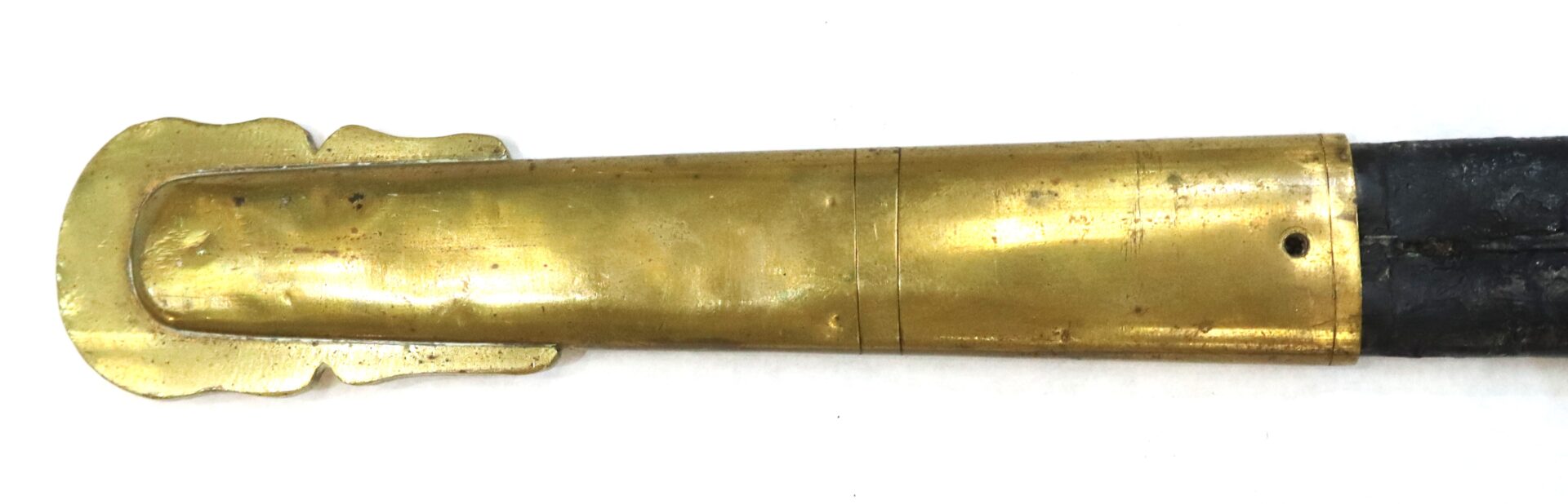 Close-up of a brass sword or dagger sheath with a decorative end, set against a white background.