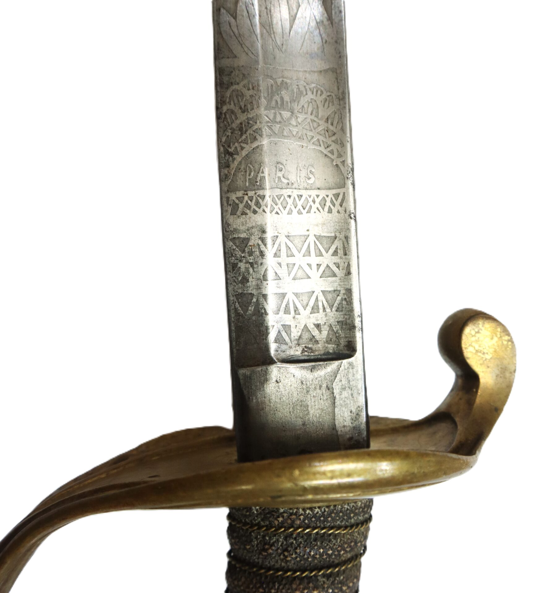 A close-up of a sword blade engraved with intricate patterns and the word "PARIS," featuring a brass guard and a wrapped handle.