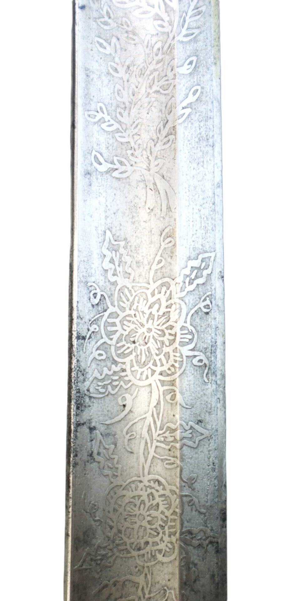 A close-up of a metal blade featuring intricate floral engravings along its surface.