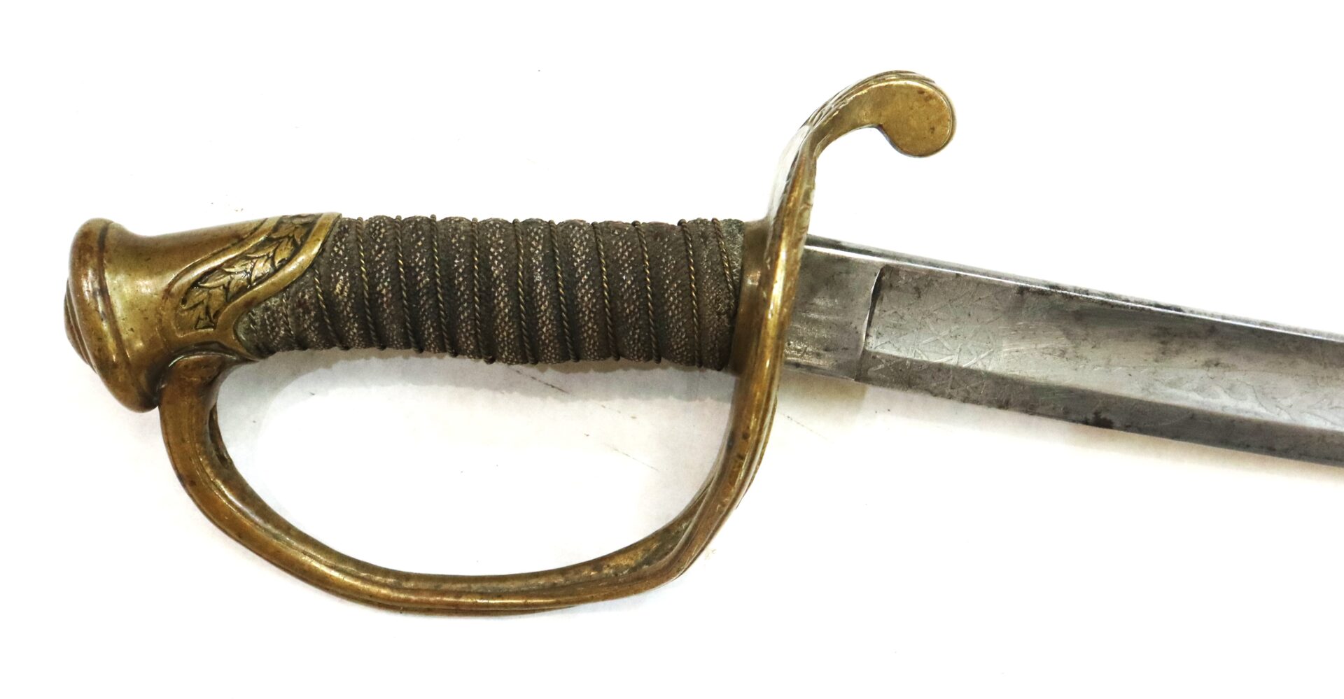 Close-up of the hilt and part of the blade of an antique sword with a brass guard and wire-wrapped grip, isolated on a white background.