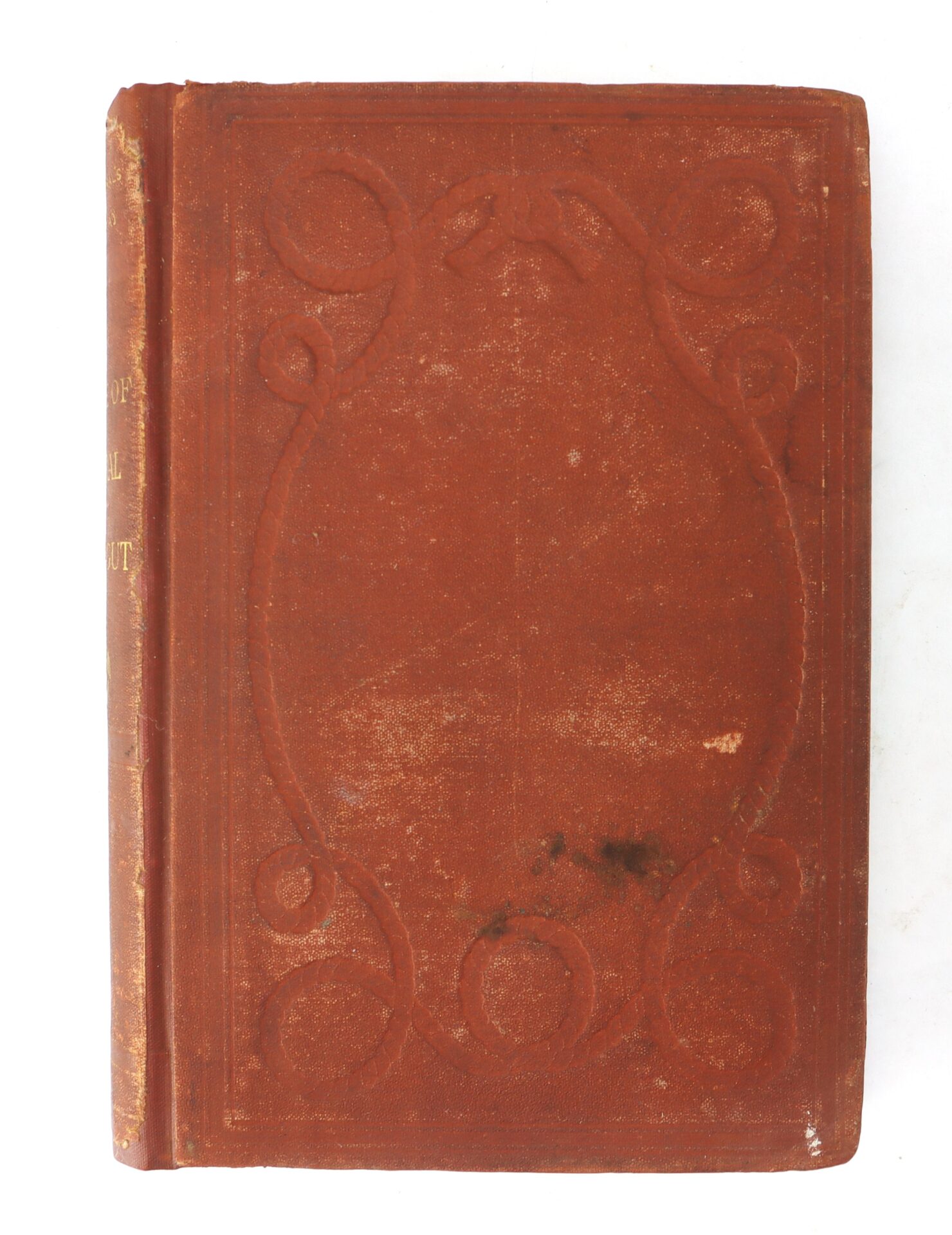A worn, reddish-brown hardcover book with embossed decorative patterns on the front cover and some visible stains.