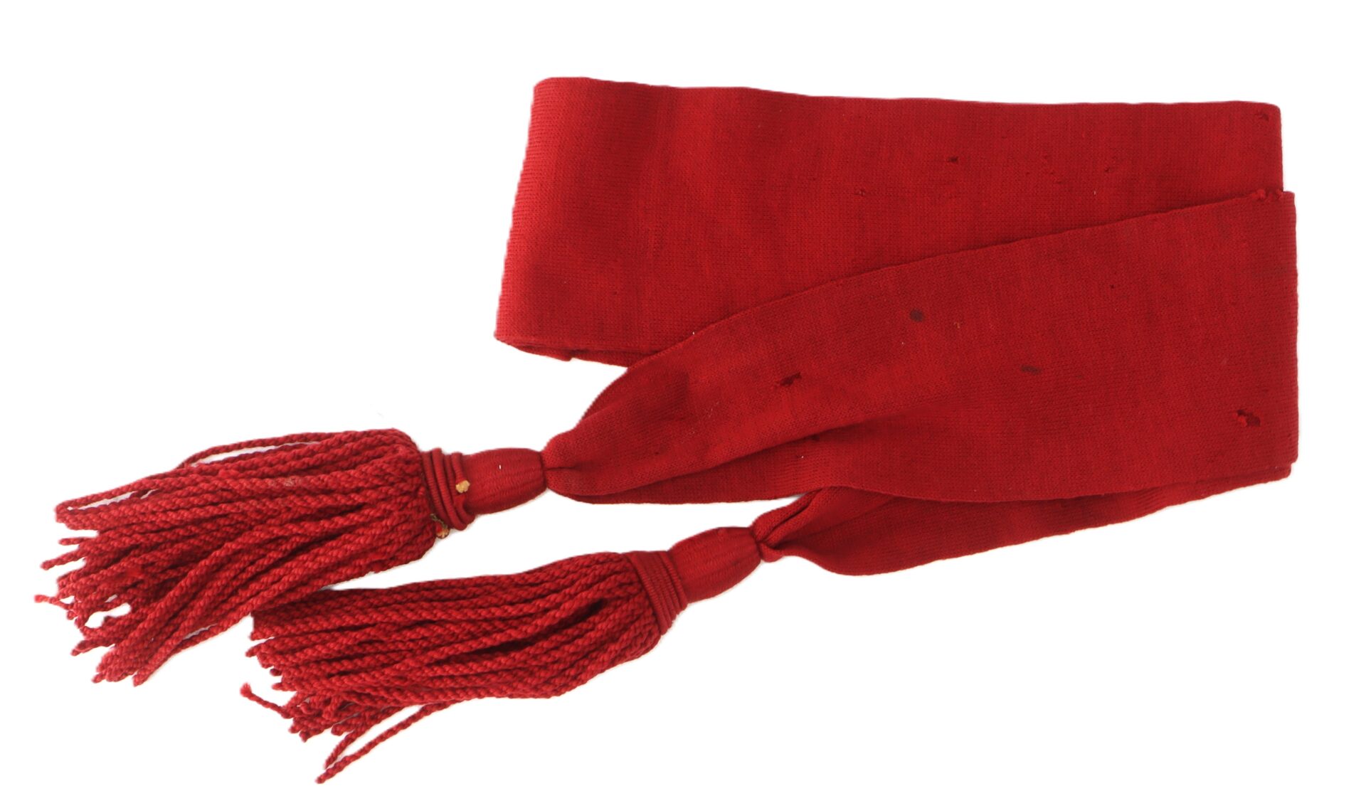 A red sash with two tasseled ends, laid out flat on a white background.