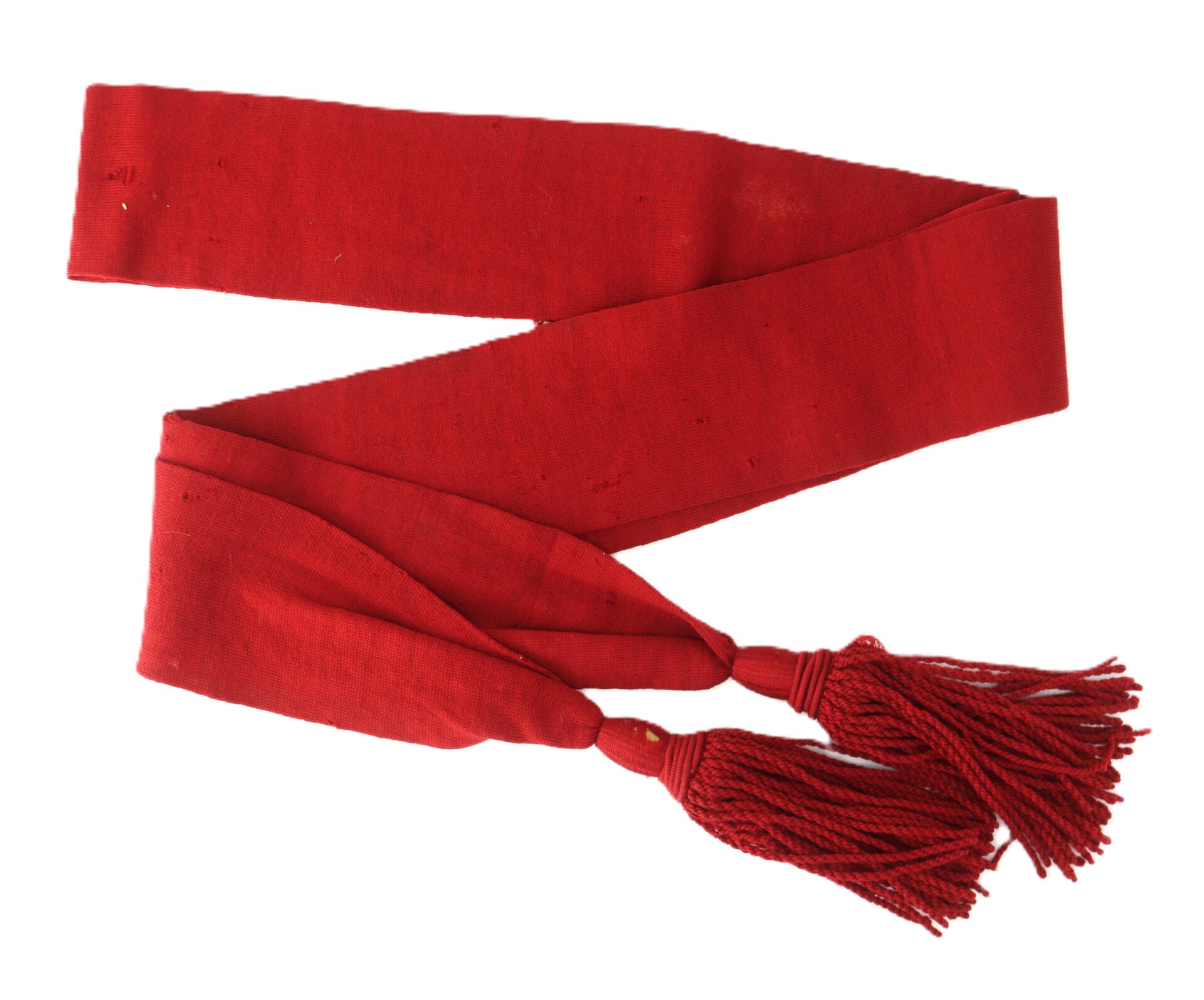 A red fabric sash with two tassels at one end, laid out flat on a white background.